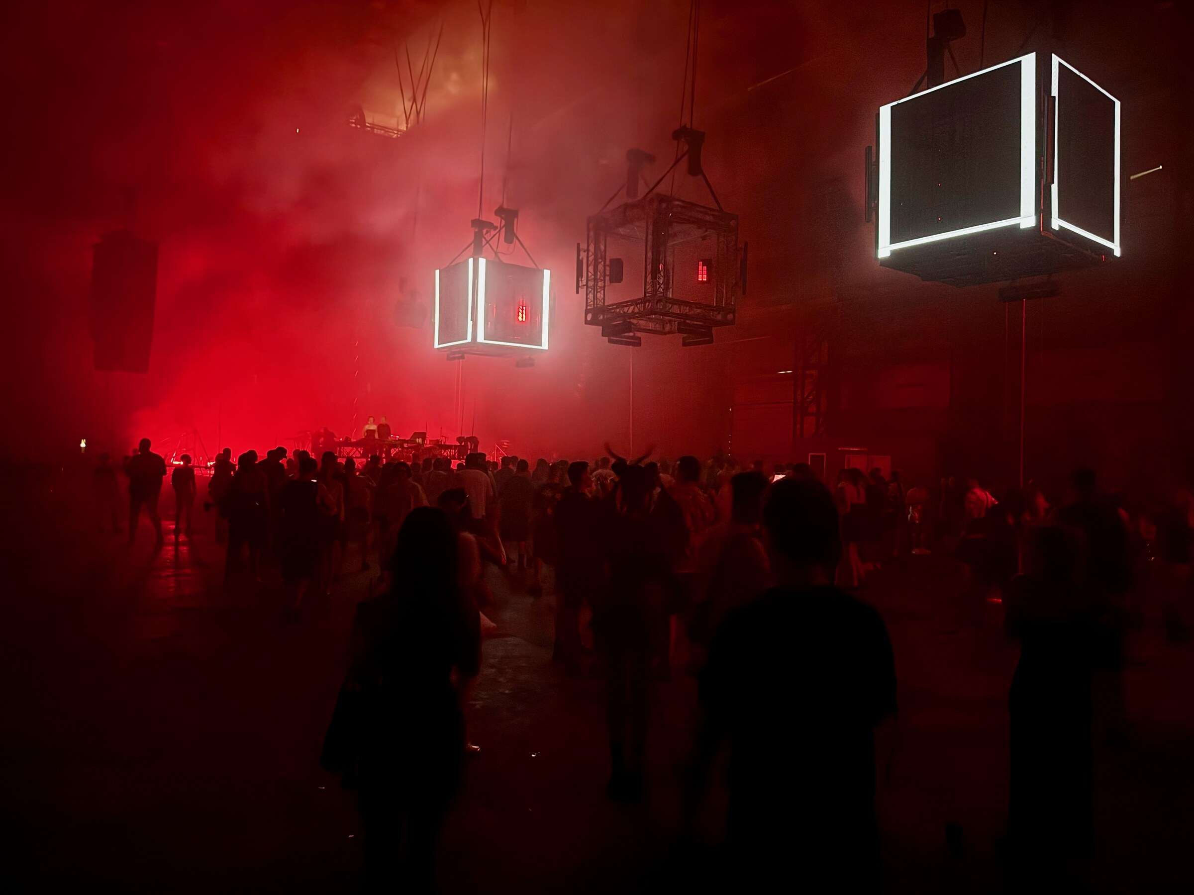 Crowd silhouetted in red light at Brave Factory