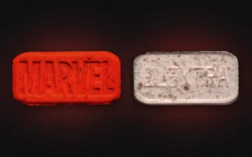 Red Marvel MDMA pill photographed from both sides, MARVEL logo on one face and ELEKTRA on the other