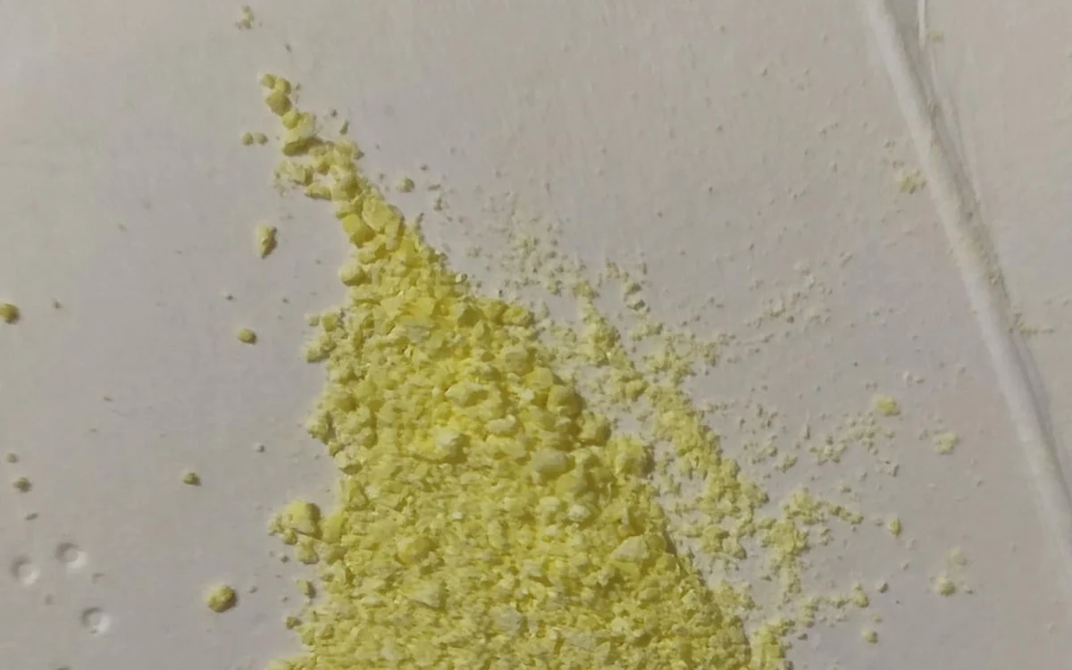 A pile of distinctly yellow amphetamine powder on a pale tile