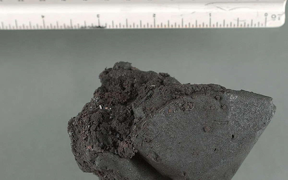 Un pezzo scuro e appiccicoso di eroina black tar accanto a un righello