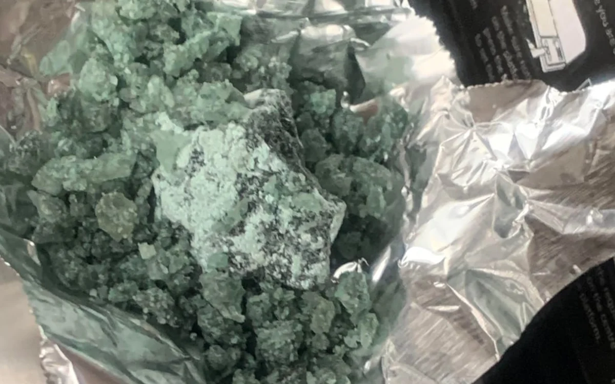Strongly green MDMA crystal inside a clear bag on foil