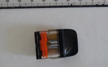 Vape pod cartridge photographed beside a ruler in a laboratory sample submission