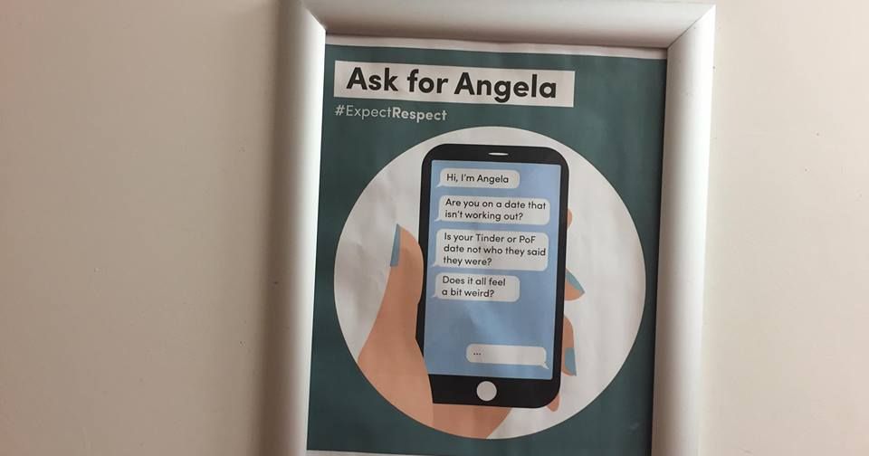 Ein gerahmtes „Ask for Angela“-Sicherheitsplakat, fotografiert an der Wand eines Veranstaltungsortes