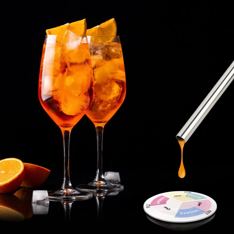 A drink test being used beside two orange cocktails