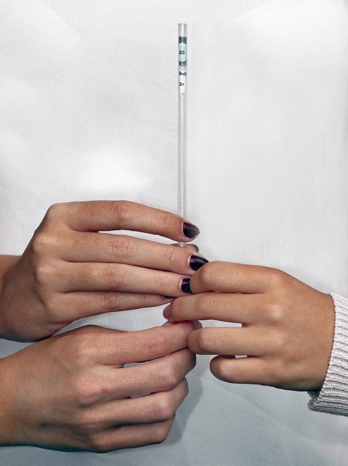 Hände halten den Smart Straw-Prototyp mit zwei markierten Testbereichen