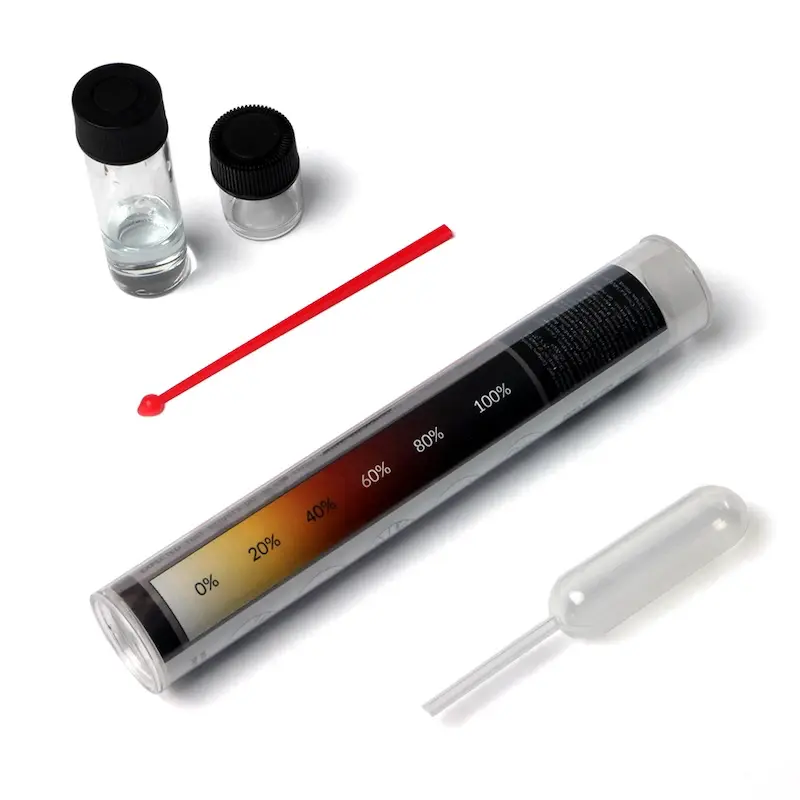 PRO Test for Cocaine Quantity: two glass vials with black caps, a red microspoon, a pipette and the storage tube printed with a colour scale from 0% to 100% in 20% steps