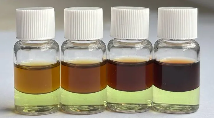 Four vials of PRO Test for Cocaine Quantity in daylight, their top layers going from orange at 25% cocaine to near black at 100%, above a pale green bottom layer
